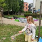 dziecko bawi się bańkami mydlanymi