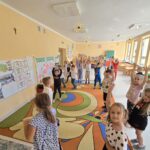 Dzieci w sali przedszkolnej wykonują ćwiczenia podczas Dnia Kropki.