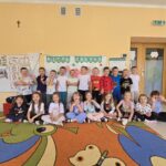 Dzieci pozują do wspólnego zdjęcia podczas świętowania Dnia Kropki.