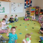 Dzieci biorą udział w quizie z wykorzystaniem czerwonych i zielonych tabliczek