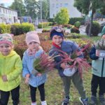 Dzieci trzymające doniczki z wrzosami