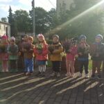 Dzieci trzymające doniczki z wrzosami