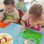 Dzieci nakładają owoce do słoików