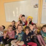 Grupka dzieci z grupy Pszczółek pozują do zdjęcia z Kubusiem Puchatkiem.