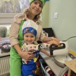 Dziecko z Panią nauczycielką miksujące potrawę w misce