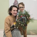 Dziecko z mamą z wykonanym na warsztatach wiankiem świątecznym