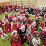 Dzieci siedzące na dywanie w oczekiwaniu na Św. Mikołaja