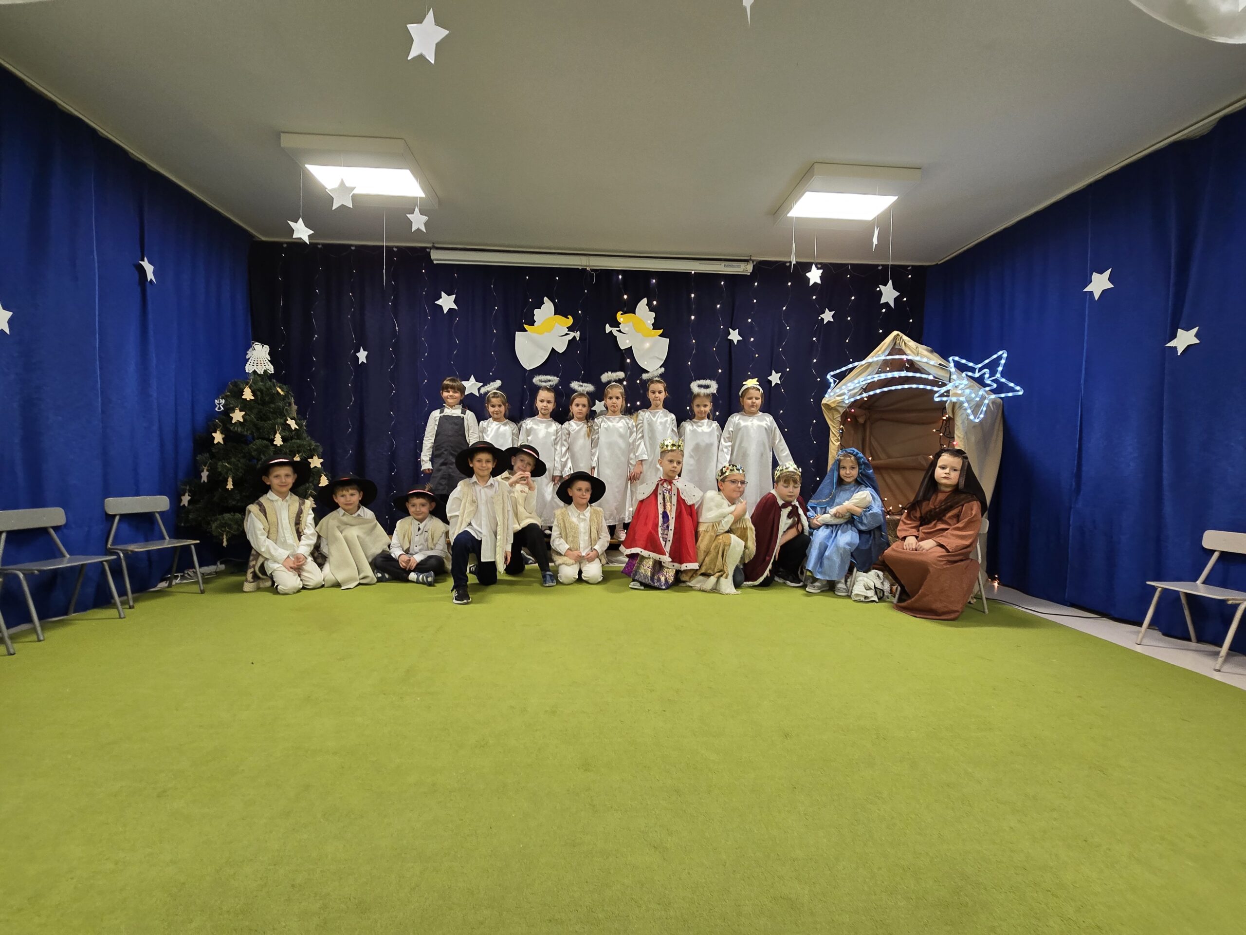 Dzieci ubrane w stroje aniołów, pasterzy, królów, Maryi i Józefa pozują do zdjęcia.