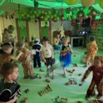 Dzieci w trakcie bitwy na śnieżki zrobionych z gazet. Wszyscy są ubrani w stroje karnawałowe