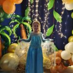 Dziecko pozuje do zdjęcia na tle dżungli