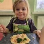 Dziewczynka z własnoręcznie przygotowaną pizzą