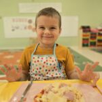 Chłopiec z własnoręcznie przygotowaną pizzą