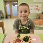 Chłopiec z własnoręcznie przygotowaną pizzą
