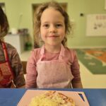 Dziewczynka z własnoręcznie przygotowaną pizzą