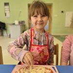 Dziewczynka z własnoręcznie przygotowaną pizzą