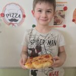 Chłopiec upieczoną, własnoręcznie przygotowana pizzą