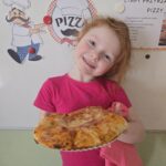 Dziewczynka z upieczoną, własnoręcznie przygotowana pizzą