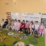 Dziewczynki z grupy przedszkolnej siedzące na krzesłach