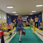 Dziewczynka w stroju ekologicznym maszeruje po wybiegu.