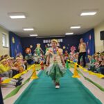Dziewczynka w stroju ekologicznym maszeruje po wybiegu.