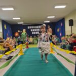 Dziewczynka w stroju ekologicznym maszeruje po wybiegu.