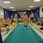 Dziewczynka w stroju ekologicznym maszeruje po wybiegu.
