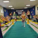 Dziewczynka w stroju ekologicznym maszeruje po wybiegu.