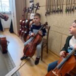 Chłopcy z grupy Pszczółki poznają instrumenty smyczkowe