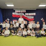 Grupa dzieci przedszkolnych pozuje do zdjęcia.