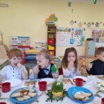 2 chłopców i dziewczynka jedzą śniadanie wielkanocne.