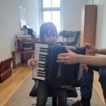 Dziewczynka próbuje gry na akordeonie