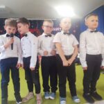 Chłopcy ubrani elegancko recytują wiersze.