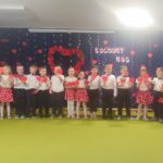 Grupa dzieci ubranych elegancko śpiewa piosenkę.