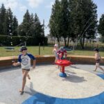 Dzieci biegające w strojach na wodnym placu zabaw