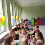 Dzieci siedzące podczas poczęstunku