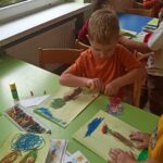 Chłopiec wykonujący pracę plastyczną