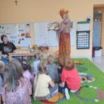 Pani bibliotekarka czyta dzieciom wiersz o jesieni