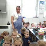 Zdjęcie to przedstawia grupę dzieci w wieku przedszkolnym aktywnie uczestniczy w zajęciach kulinarnych.